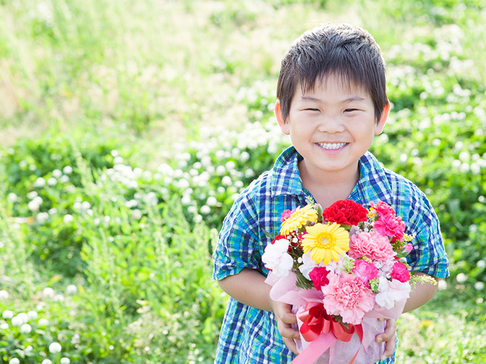 花束を持つ笑顔の男の子